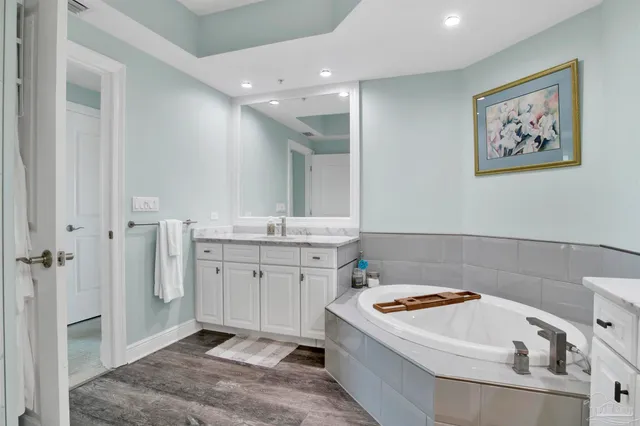 a bathroom with a tub sink and mirror