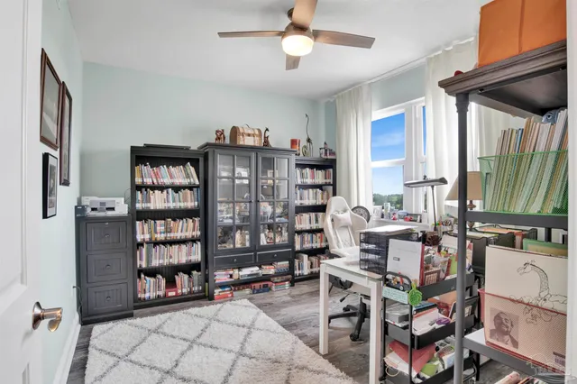 a living room with furniture a bookshelf and a window