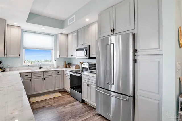 a kitchen with cabinets stainless steel appliances and a window