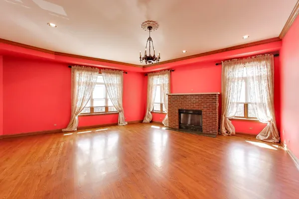 a view of empty room with wooden floor and fireplace