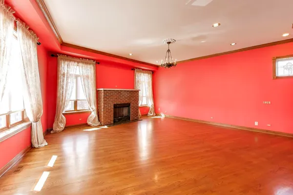 a view of empty room with wooden floor and fireplace