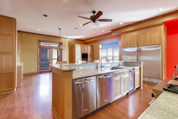 a kitchen with stainless steel appliances granite countertop a sink a stove and a refrigerator