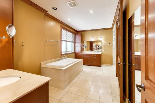 a spacious bathroom with a mirror and a tub