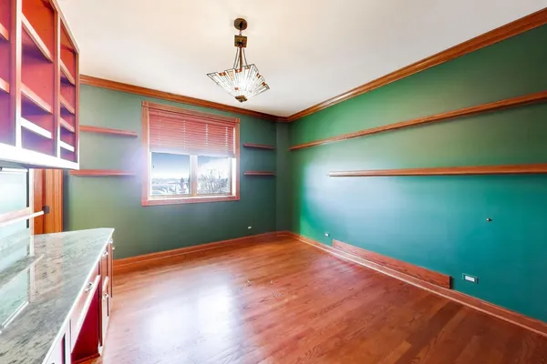 a view of a room with kitchen kitchen cabinetry and a chandelier