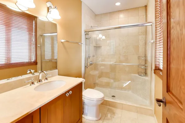 a bathroom with a sink a toilet and shower