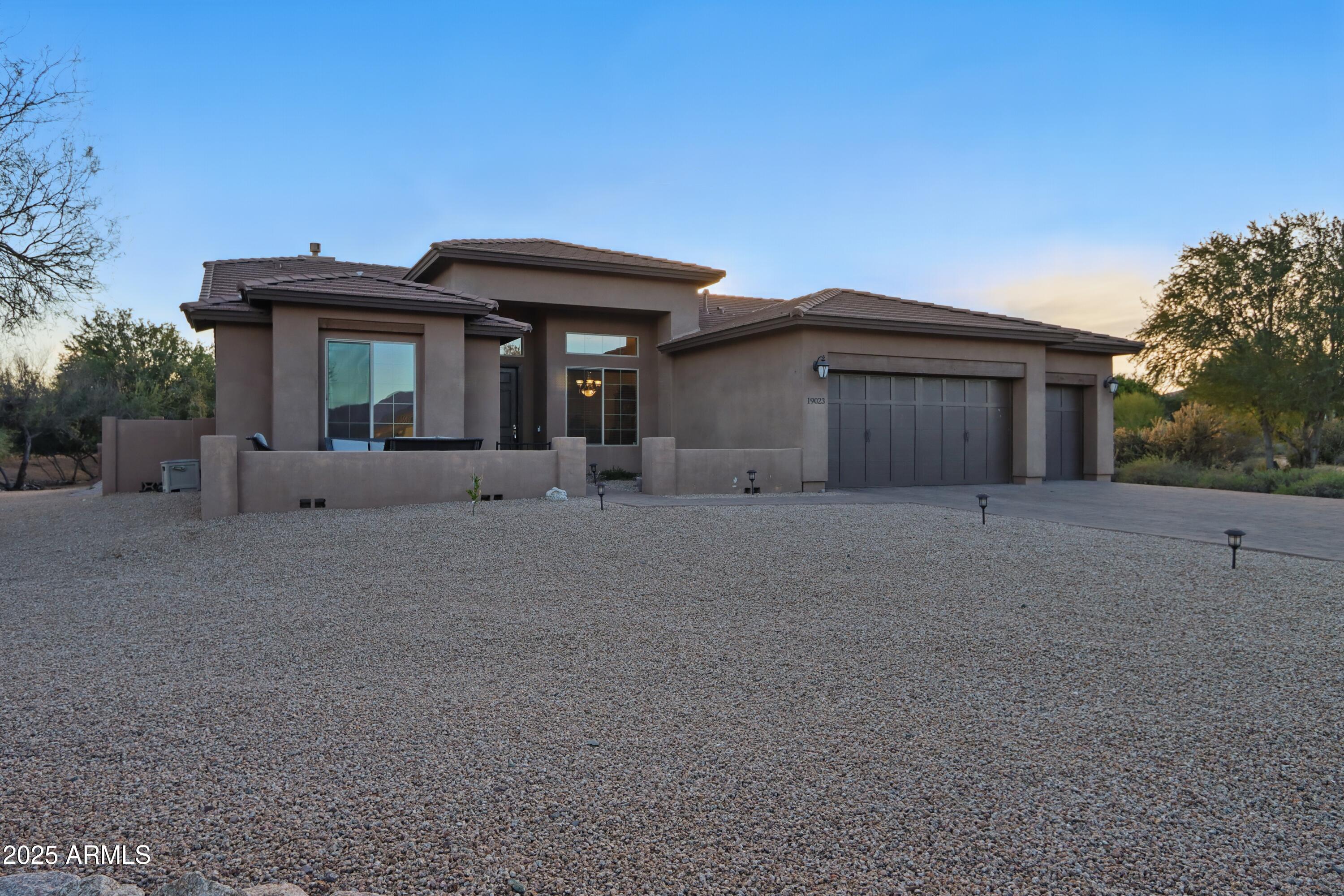 19023 East Buckskin Drive Rio Verde, AZ 85263 - Photo 2 of 31 a front view of a house with garden