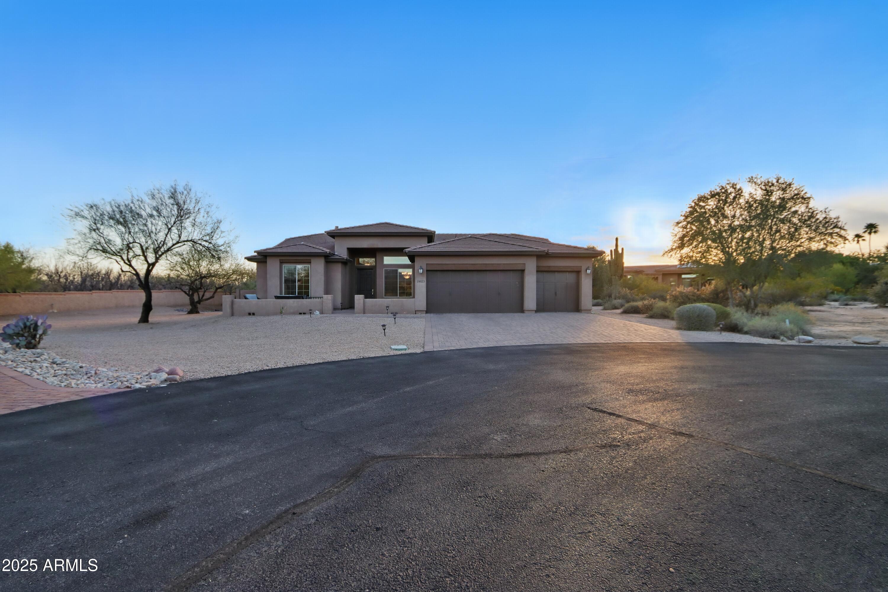 19023 East Buckskin Drive Rio Verde, AZ 85263 - Photo 51 of 58 a front view of a house with a yard and garage