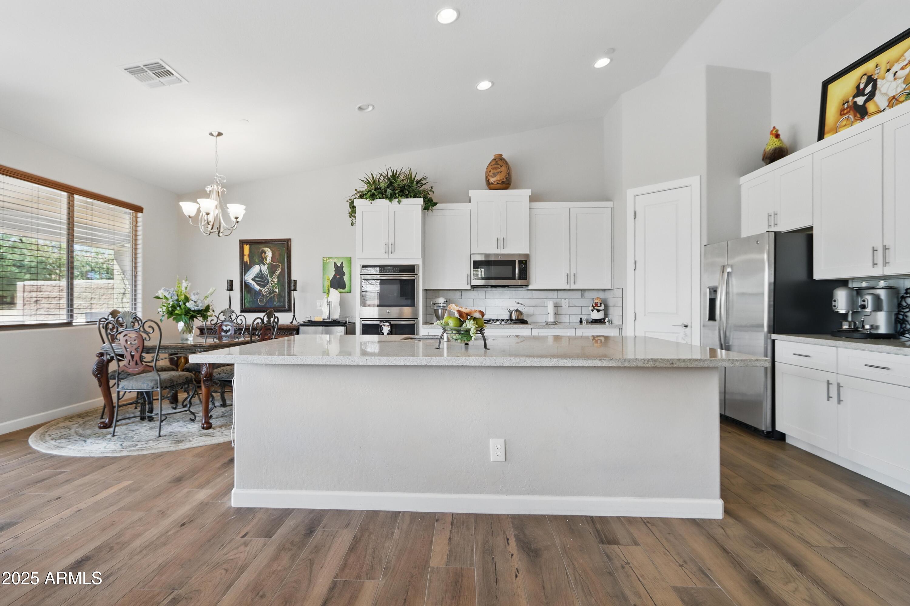 19023 East Buckskin Drive Rio Verde, AZ 85263 - Photo 10 of 58 a large white kitchen with lots of counter top space and living room view