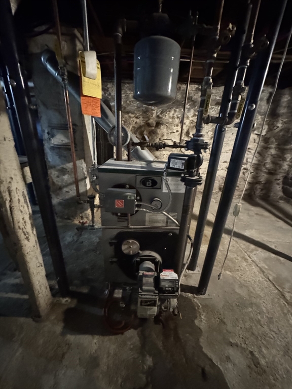 448 Pleasant Street Gardner, MA 01440 - Photo 8 of 10 a room with water heater and wooden racks