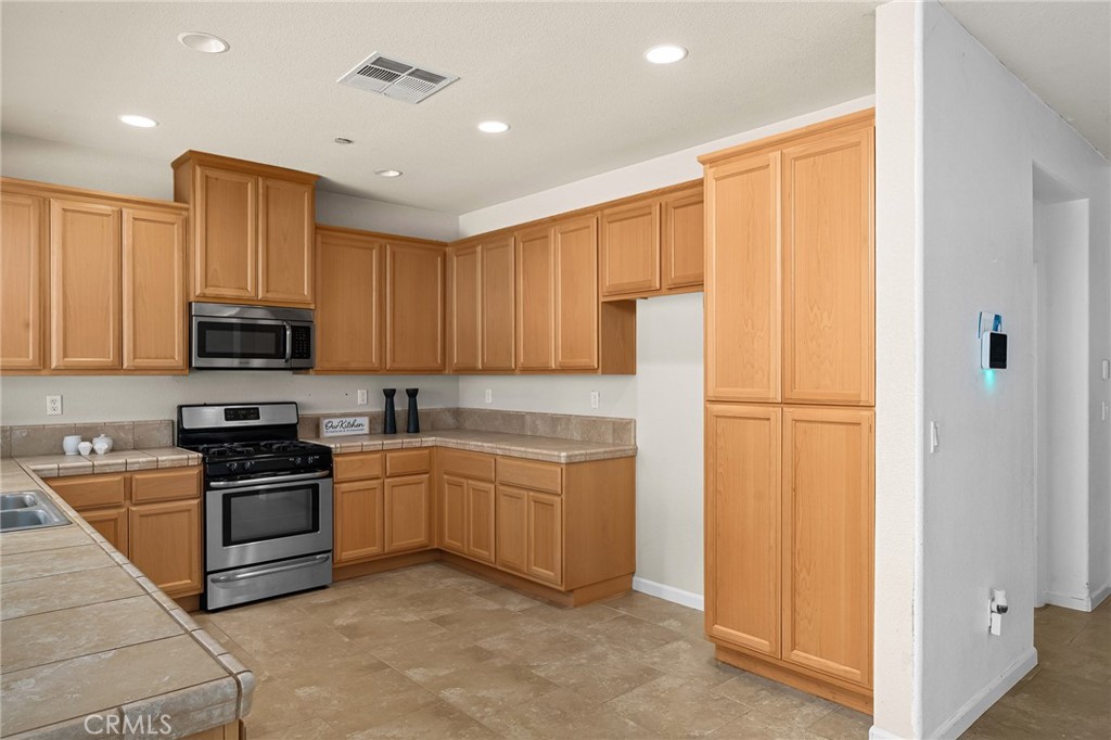 2135 Jacob Street Gridley, CA 95948 - Photo 14 of 50 a kitchen with white cabinets and stainless steel appliances