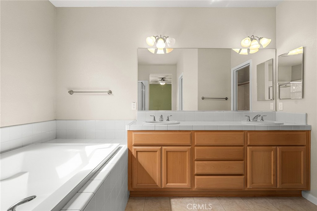 2135 Jacob Street Gridley, CA 95948 - Photo 29 of 50 a bathroom with a tub a double vanity sink and a large mirror