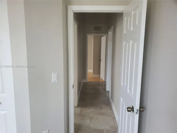 a view of a hallway with a wooden door