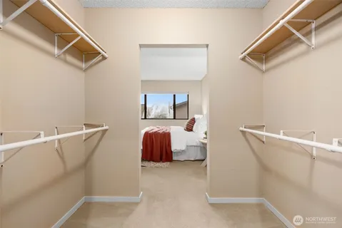 a view of walk in closet with clothes and shoes