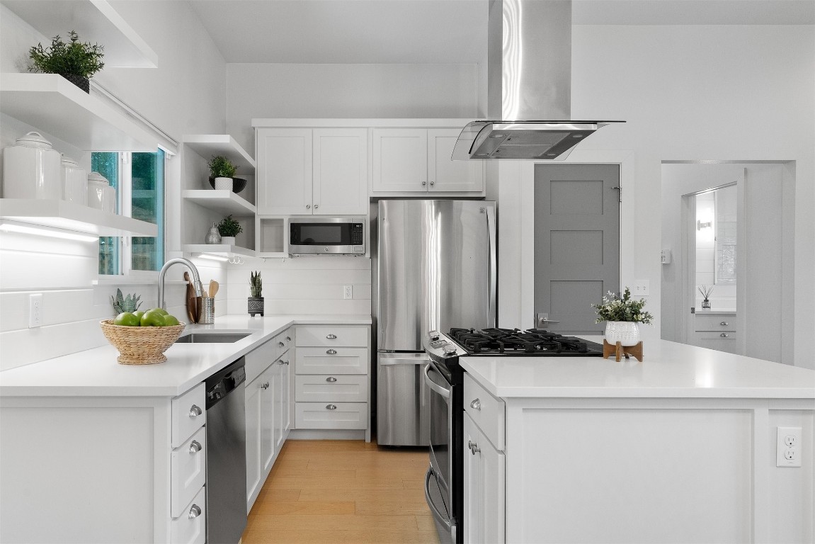a kitchen with stainless steel appliances a sink a stove and refrigerator