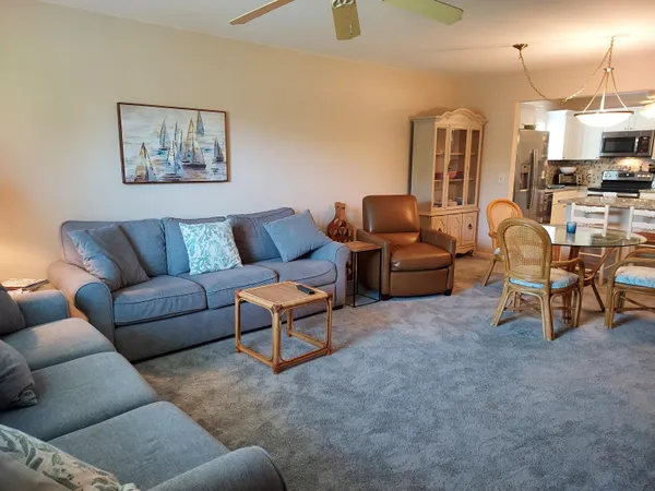 a living room with furniture and a view of kitchen