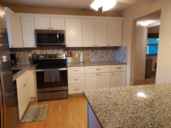 a kitchen with stainless steel appliances granite countertop a stove and a microwave