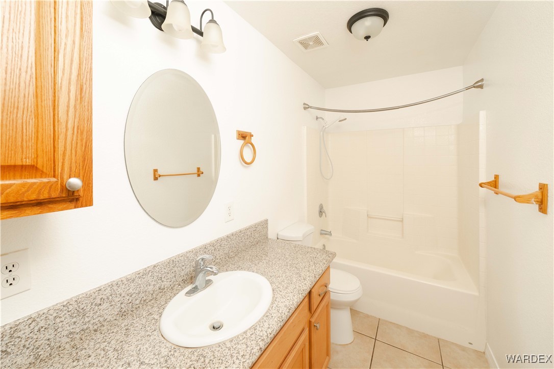 4246 Canelo Road Golden Valley, AZ 86413 - Photo 27 of 54 a bathroom with a granite countertop sink mirror and a bathtub