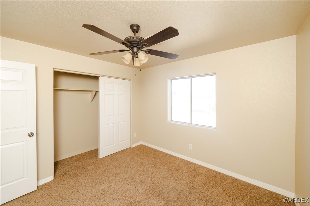 4246 Canelo Road Golden Valley, AZ 86413 - Photo 32 of 54 a view of a big room with a ceiling fan and windows