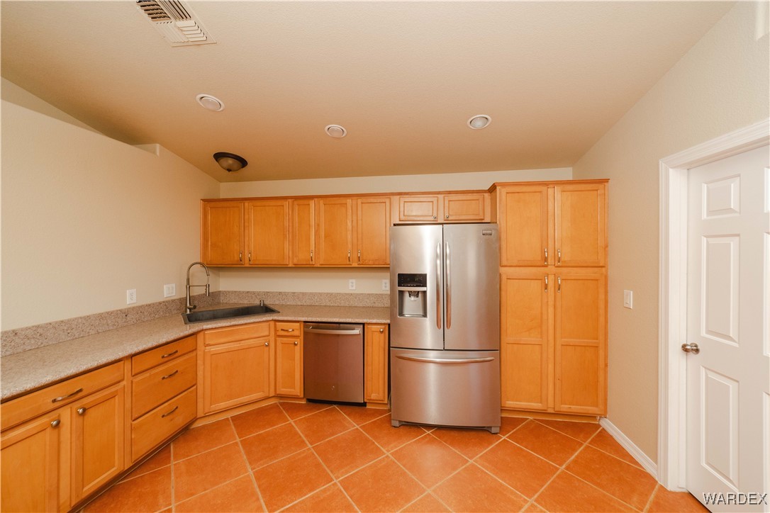 4246 Canelo Road Golden Valley, AZ 86413 - Photo 40 of 54 a kitchen with stainless steel appliances granite countertop a refrigerator a sink and white cabinets
