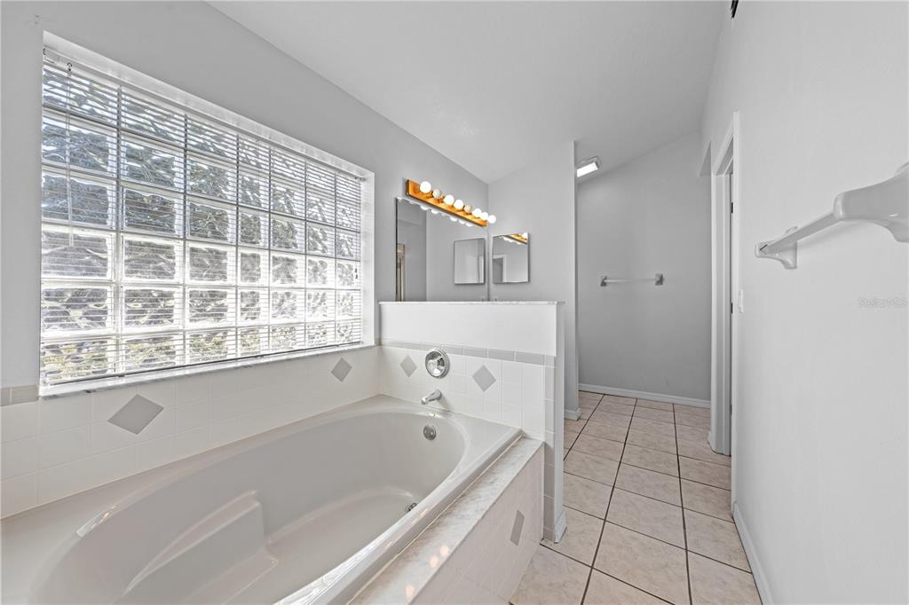 2708 Kayak Court St. Cloud, FL 34772 - Photo 12 of 56 a bathroom with a bathtub and a shower