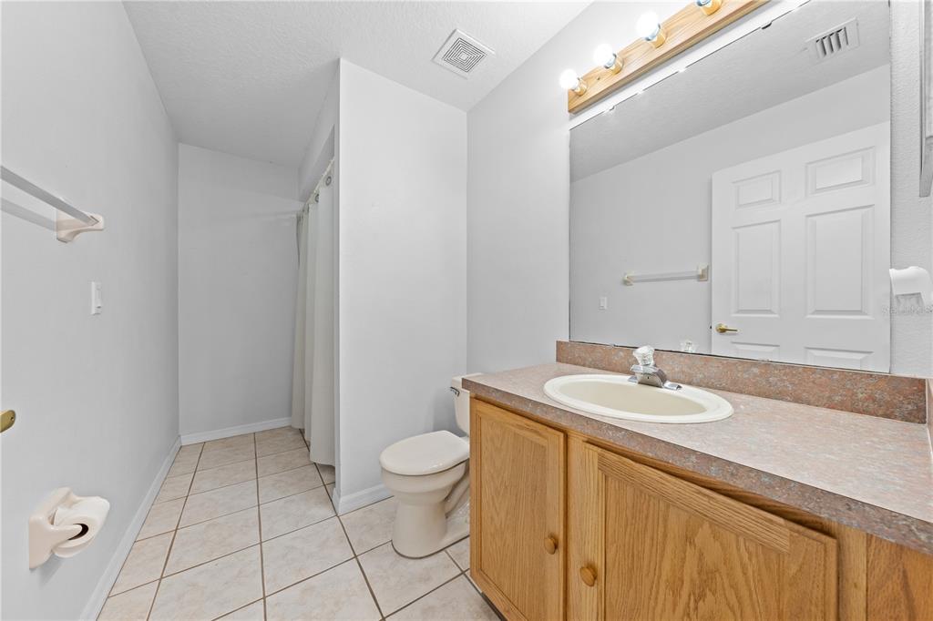2708 Kayak Court St. Cloud, FL 34772 - Photo 19 of 56 a bathroom with a granite countertop sink a toilet and a mirror