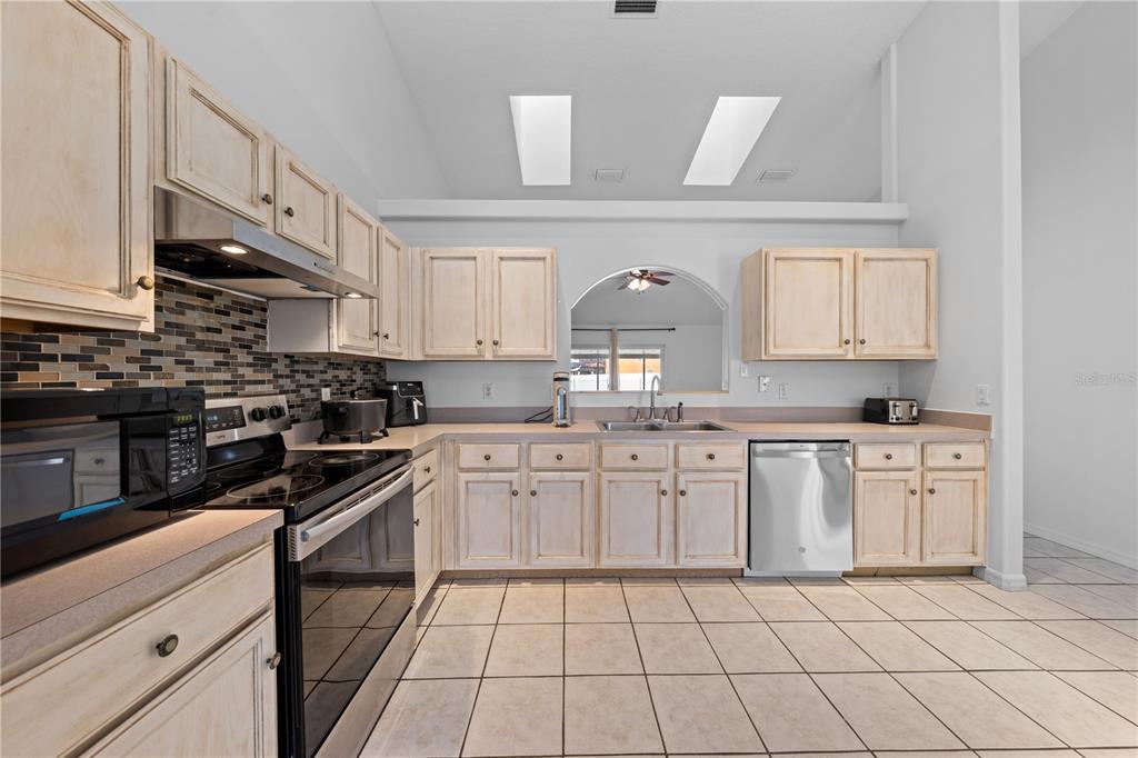 2708 Kayak Court St. Cloud, FL 34772 - Photo 40 of 56 a kitchen with stainless steel appliances granite countertop a sink and cabinets