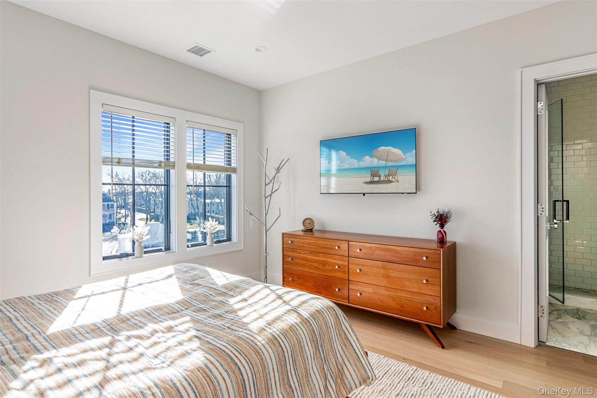 123 Sterling Avenue, Unit 12 Greenport, NY 11944 - Photo 21 of 29 a bedroom with a bed a dresser and a large window