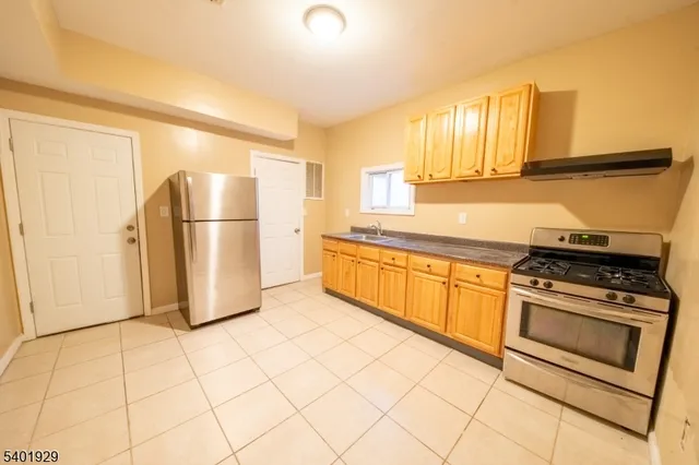 a kitchen with a refrigerator sink and cabinets
