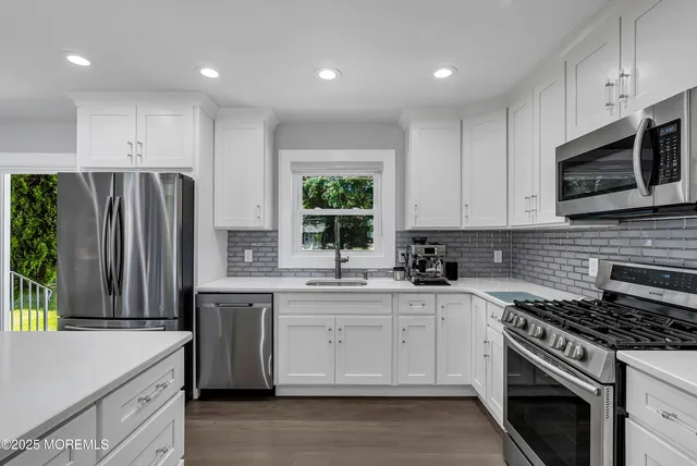 a kitchen with stainless steel appliances a stove sink and microwave