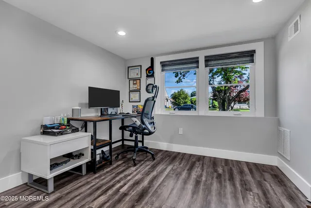 a view of a workspace with furniture and a window