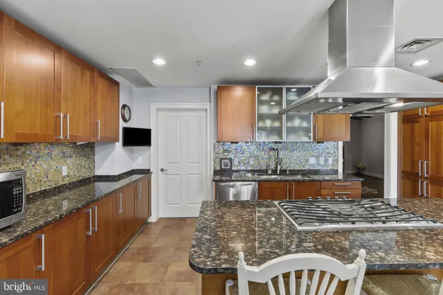 a large kitchen with kitchen island granite countertop wooden cabinets and a granite counter tops