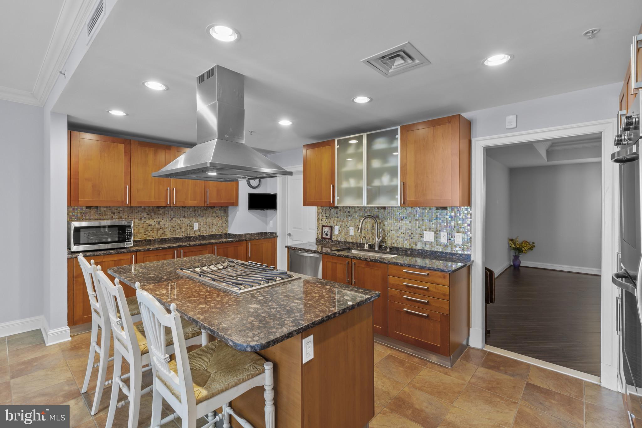 801 Key Highway, Unit 251 Baltimore, MD 21230 - Photo 13 of 57 a kitchen with stainless steel appliances granite countertop table chairs sink and cabinets