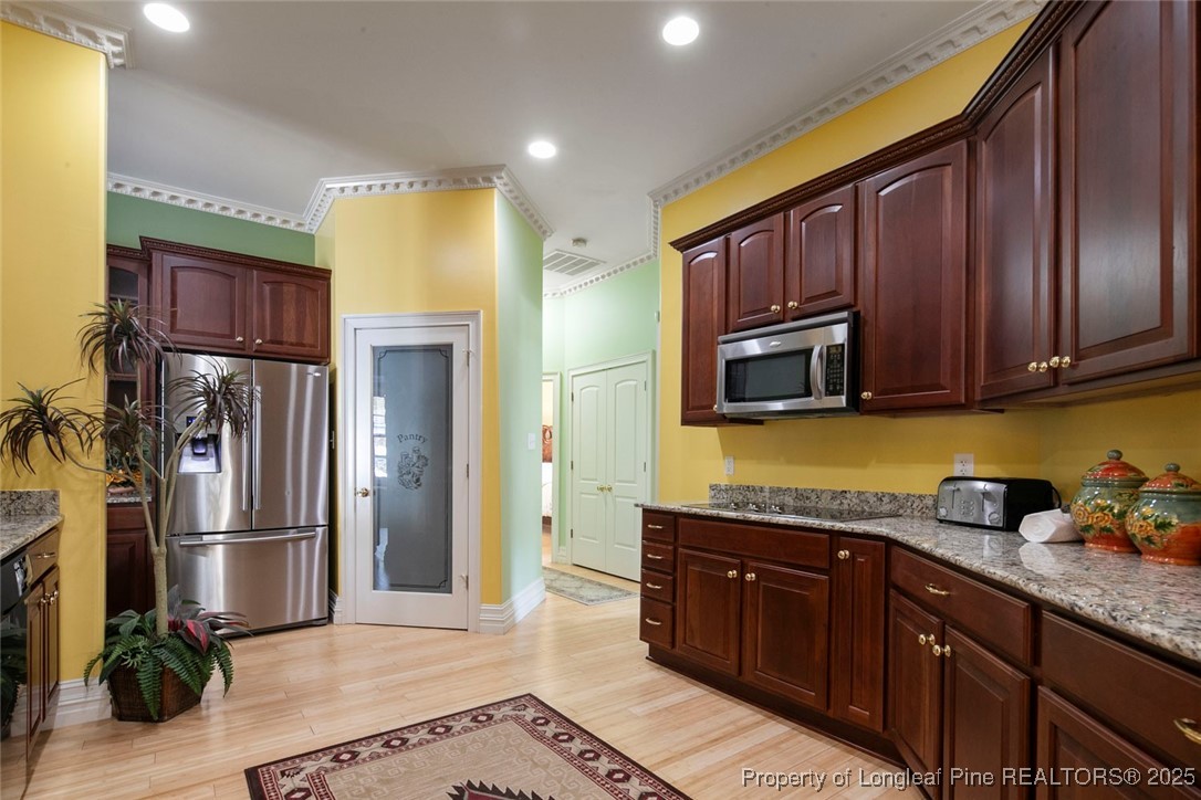 5304 Pineview Road Lumberton, NC 28360 - Photo 22 of 49 a kitchen with stainless steel appliances granite countertop a refrigerator a stove and a sink with wooden cabinets