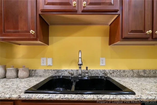 a en suite bathroom with a granite countertop sink a mirror and shower