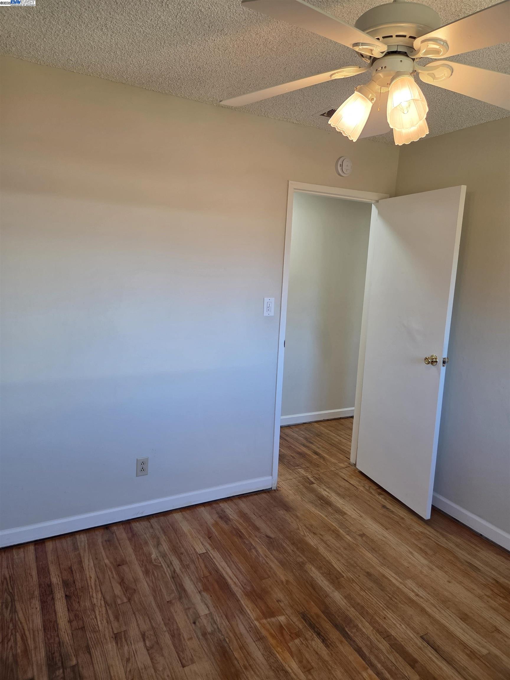 6198 Hancock Avenue San Jose, CA 95123 - Photo 13 of 27 a view of an empty room with wooden floor and a chandelier fan