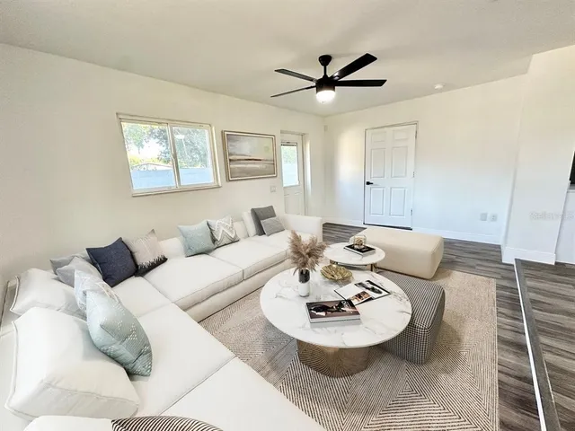 a living room with furniture and a view of kitchen