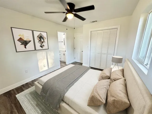 a bedroom with a bed and a painting on the wall