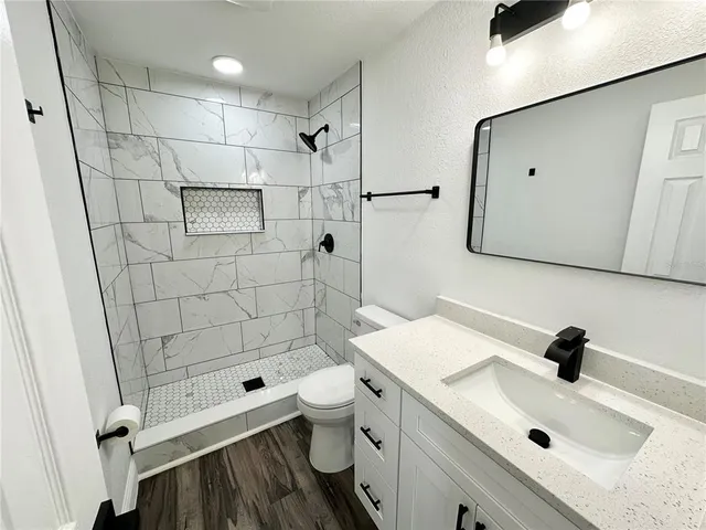 a bathroom with a sink a toilet and shower