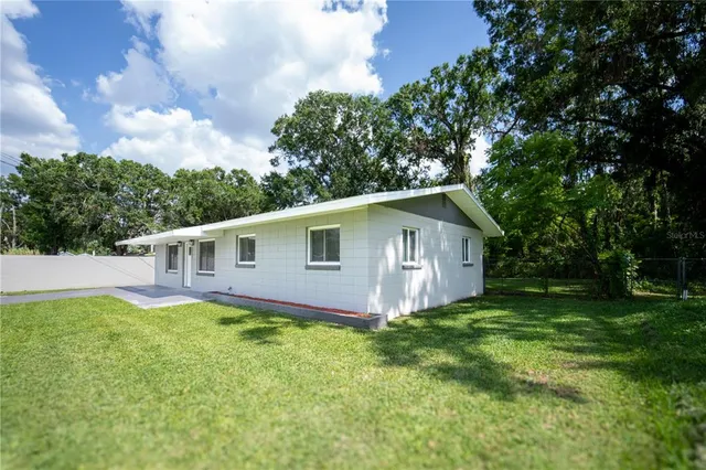 a front view of house with yard and trees in the background