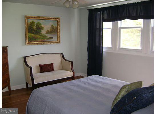 5573 Ashbourne Road Halethorpe, MD 21227 - Photo 3 of 30 a bedroom with a bed and a painting on the wall