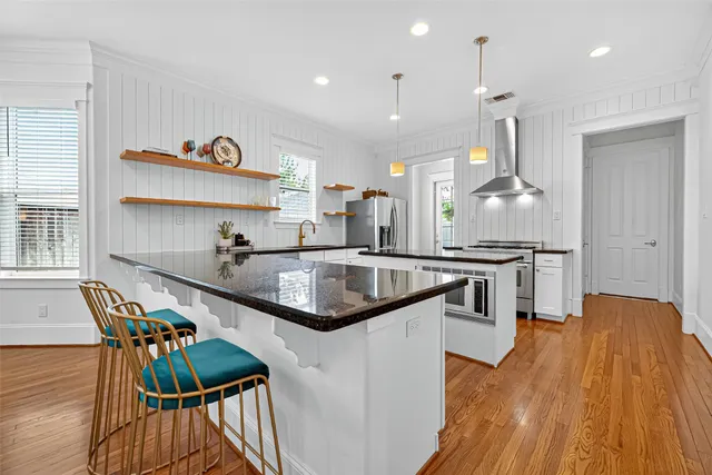 a kitchen with stainless steel appliances granite countertop lots of counter top space and wooden floor