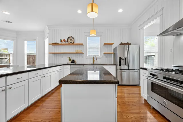 a kitchen with stainless steel appliances granite countertop a stove and a refrigerator