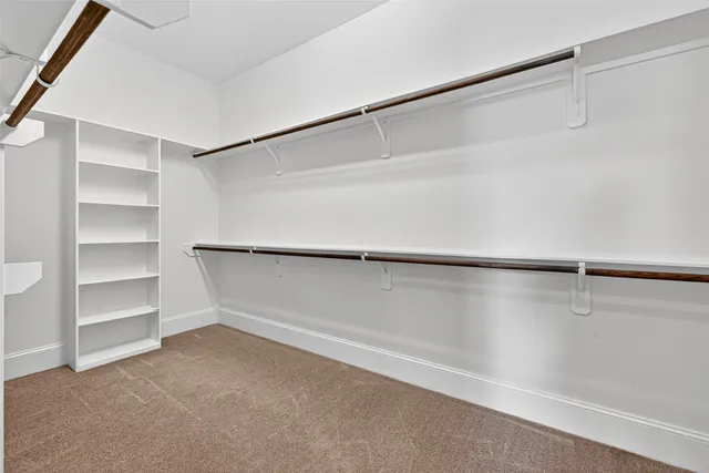 a view of walk in closet with empty racks