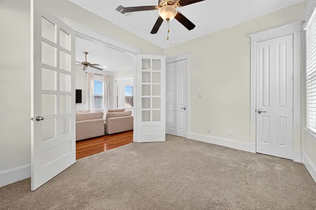 an empty room with a window and a ceiling fan