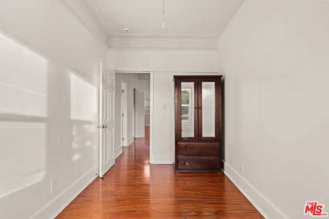 a view of a hallway with wooden floor and closet