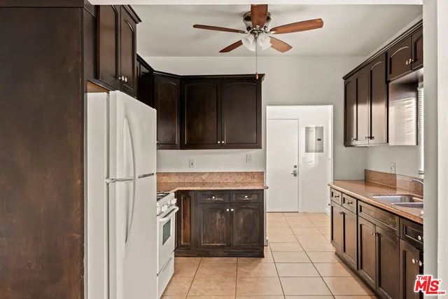 a kitchen with stainless steel appliances granite countertop a refrigerator a stove and a sink