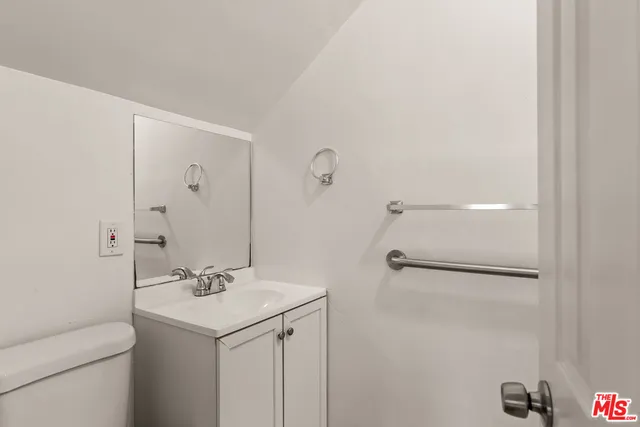 a bathroom with a sink and mirror with toilet