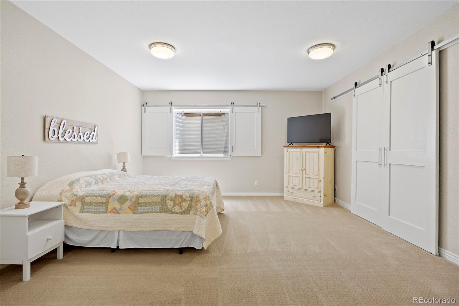 38666 County Road 21 Elizabeth, CO 80107 - Photo 35 of 48 a spacious bedroom with a bed and a flat screen tv