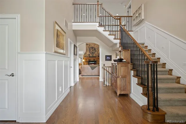 a kitchen with a stove a refrigerator and a dining table with wooden floor