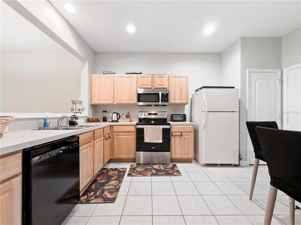 2617 Redford Way Wesley Chapel, FL 33544 - Photo 12 of 21 a kitchen with a sink a refrigerator and a stove top oven with wooden floor